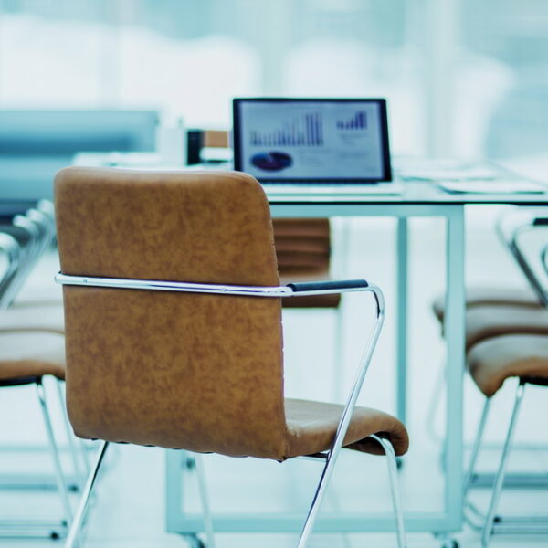 open laptop computer with financial charts on the table with the Manager in a modern office. the photo is a blank space for your text